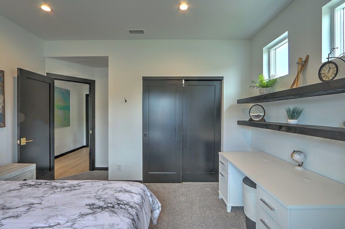 A bedroom with a bed, a wardrobe, a dresser, and a shelf with decorative items.