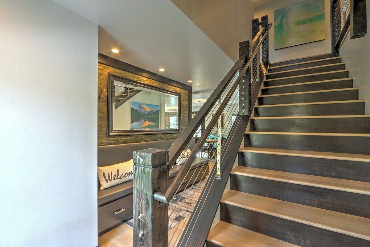 A staircase with a wooden handrail and metal balusters, leading to a landing with a framed picture and a 'Welcome' sign.