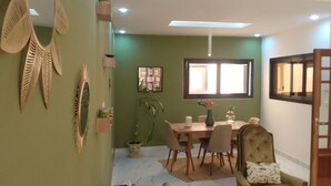 Un comedor con una mesa, sillas y un jarrón de flores.