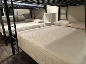 A dormitory room with bunk beds, a white wardrobe, and a shelf unit. -  Spectacular Lakefront Home- sleeps 20 ~ Hot Tub - Walk To Restaurants! (Lake Harmony)