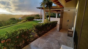 A modern house with a covered patio, a view of the surrounding landscape, and a well-maintained lawn. - Casa Hacienda Jaguar (Ciudad Cortés)