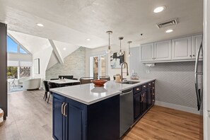 Enjoy cooking in this well-equipped kitchen with a central island, sink, and dishwasher, and dine in the adjacent dining area.