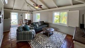 A spacious living area with a high ceiling, a ceiling fan, a sofa set, a coffee table, and a patterned rug. - 5 Minute walk to the beach! (Christiansted)