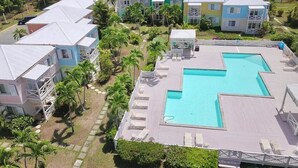A resort with multiple colorful buildings, a large swimming pool, and palm trees. - 5 Minute walk to the beach! (Christiansted)