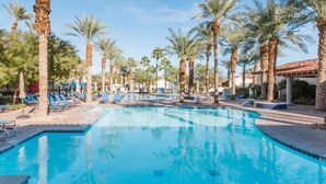 A swimming pool with lounge chairs and palm trees. - Mountain Vista B | Studio Legacy Villa (La Quinta)