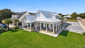 A two-story house with a covered patio and a car parked in the driveway. - New 3 Bedroom Beachfront Rental in downtown Bay St Louis (Bay St. Louis)