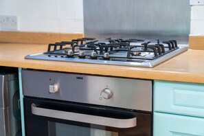 A kitchen with a gas stove, a built-in oven, and a stainless steel range hood.