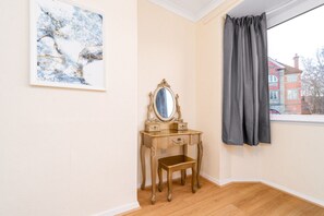 A room with a wooden vanity, a mirror, a framed artwork, and a window with curtains. - Stylish Three Bedroom House - Harborne - Parking - Garden (Harborne)