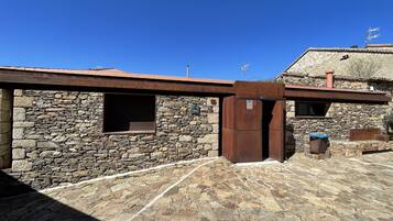 A stone building with a metal door and a window.