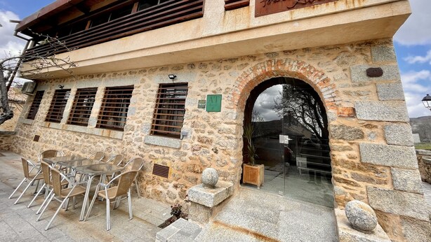 Un edificio con fachada de piedra, puerta de entrada de vidrio y un letrero que dice "Casa de la Luna".
