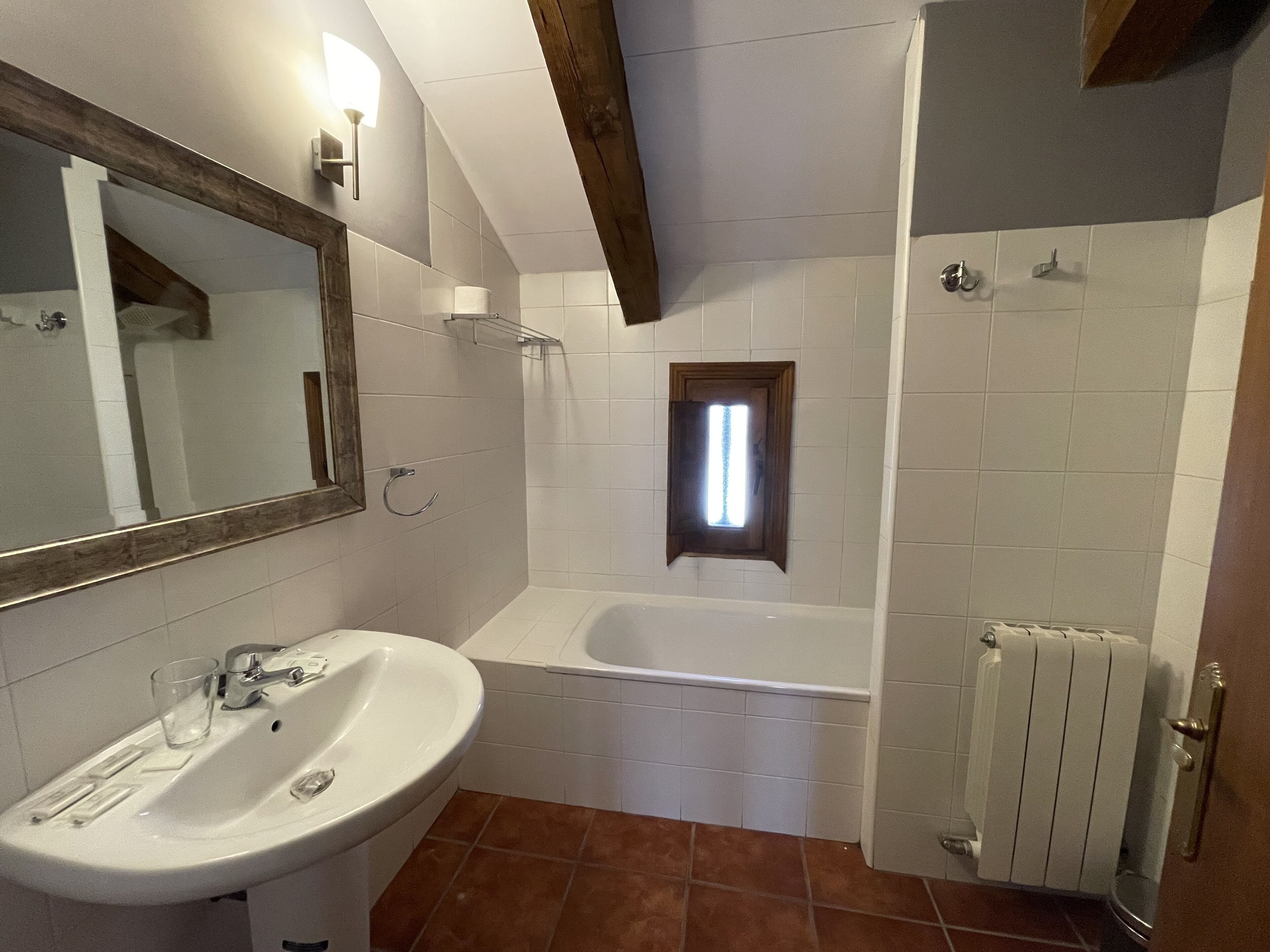 Un baño con lavabo, espejo y bañera.