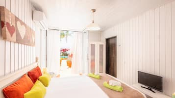 A hotel room with a bed, a TV, and a view of the outside.
