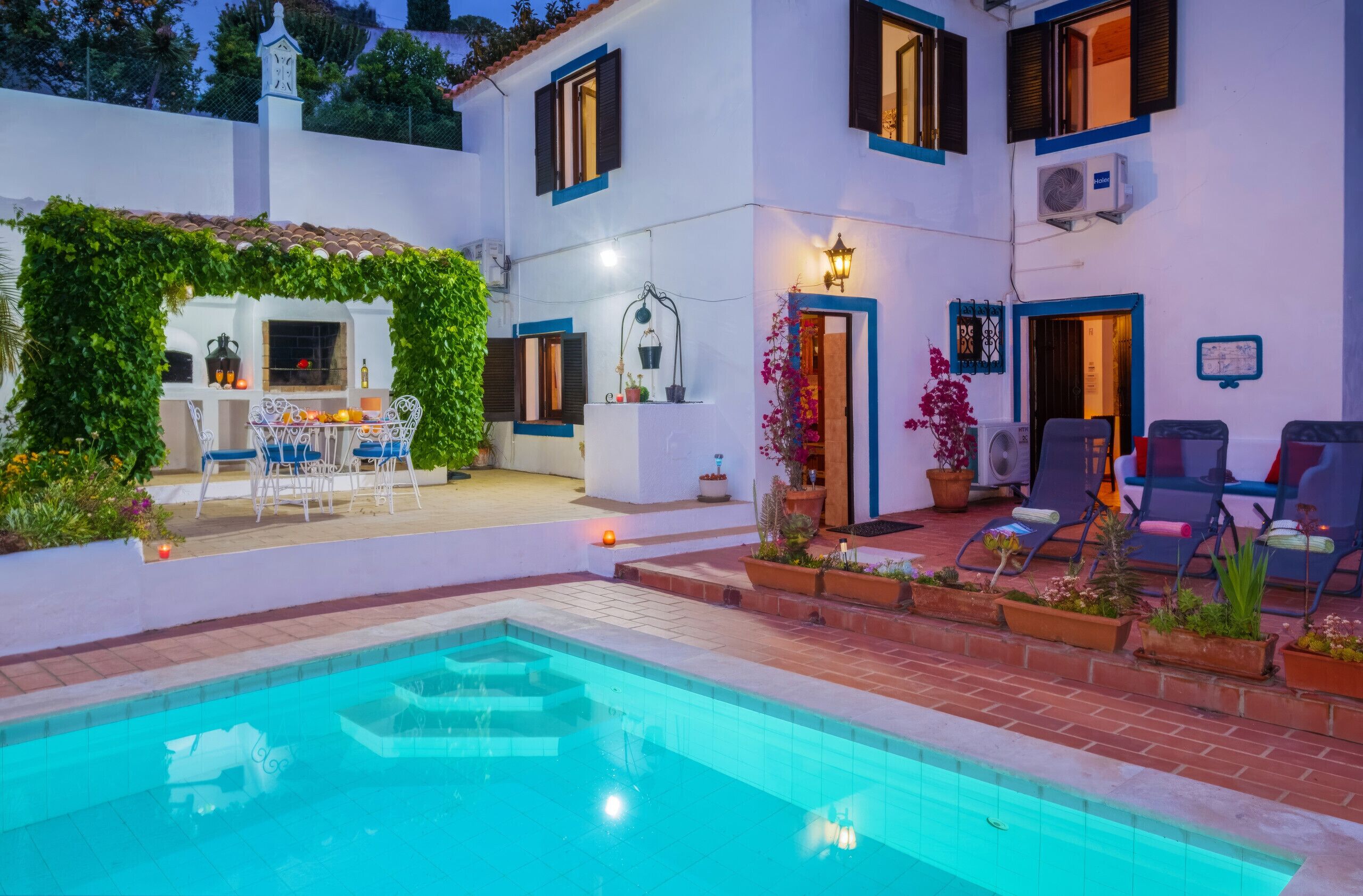 A poolside area with a pool, outdoor seating, and a covered patio.