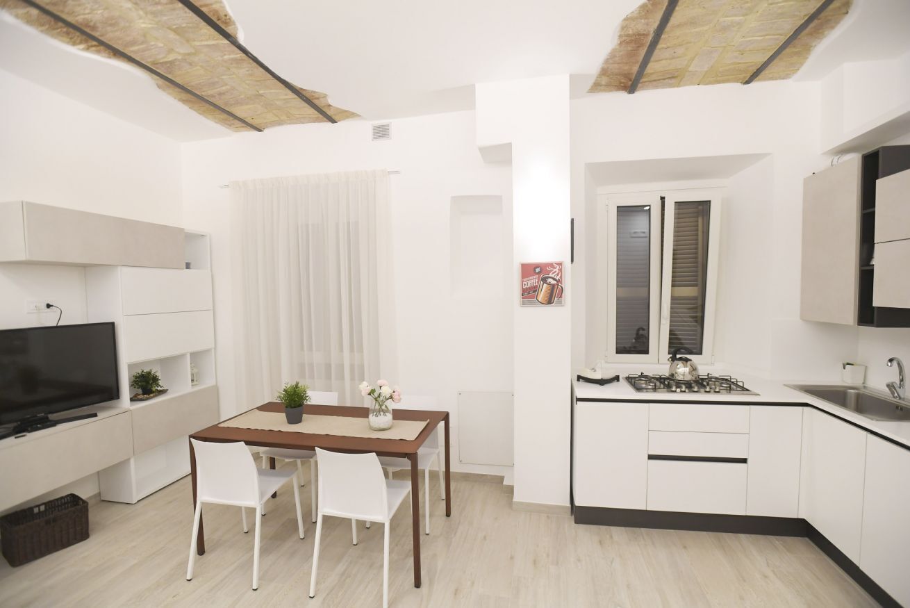 A compact living space with a kitchenette, dining area, and a TV.