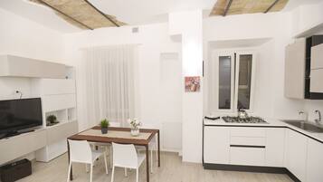 A compact living space with a kitchenette, dining area, and a TV.