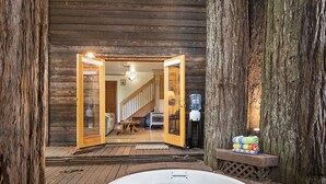 L’intérieur d’un chalet en bois comprend un jacuzzi, un plancher en bois et un escalier menant à une mezzanine.