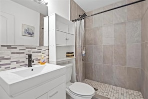 Un baño moderno con ducha, inodoro y lavamanos.