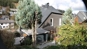 Ein Wohnhaus mit Satteldach, Garage und weißem Zaun.