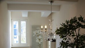 Eine Treppe mit einem Holnändergeländer, einem Blumentopf und einer Chandelier.