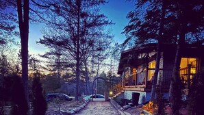 A pathway leading to a building with a metal gate, surrounded by trees and a clear sky. - Summer Getaway - 3 min walk to Beach, Clean & Cozy (Tiny)