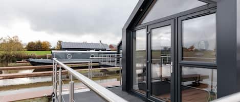 A modern building with large windows overlooking a canal.
