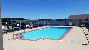 A rectangular pool with a red border, surrounded by a concrete deck. There are lounge chairs and a lifebuoy on the deck. - Willow Beach Resort (Hot Springs)