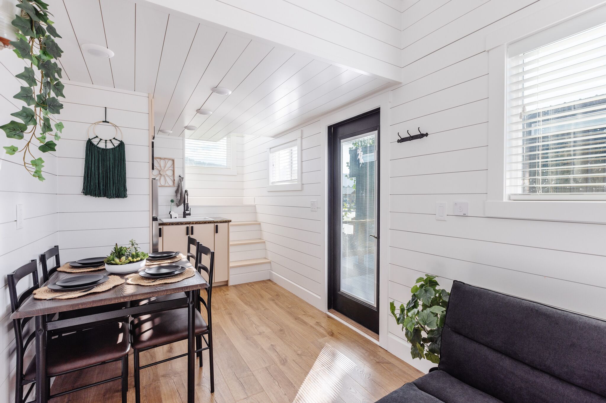 A modern interior with a dining area, a sofa, and a kitchen.