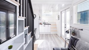 A modern kitchen with white cabinets, a black countertop, and a small island. - Zion's Tiny Getaway (Hurricane)