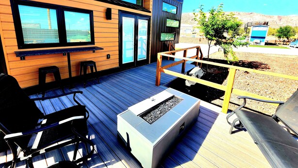 A modern outdoor deck with a built-in grill and seating area. - Zion's Tiny Getaway (Hurricane)