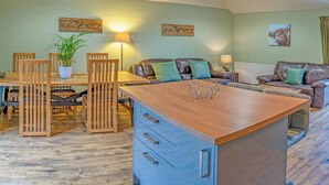 A cozy living room with a wooden dining table, chairs, a sofa, and a coffee table. - Keepers Cottage - UK30246 (Glenshee, Cairngorms)
