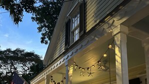A two-story house with a porch, a white picket fence, and an American flag. - Old Town Classic with plenty of charm, porch swing and parking (Key West)