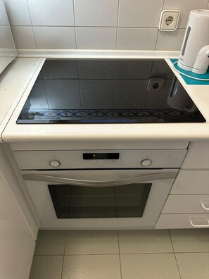 Cocina compacta con estufa integrada, horno y microondas.