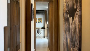 A modern hallway with mirrored walls, a large Buddha painting, and a view into a dining area. - Luxury apartment with ocean view only 5 min from the historic center. (Cartagena de Indias)