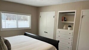 A bedroom with a bed, a wardrobe, and a built-in shelving unit. - Cozy Stay Near National Parks & BYUI - Sleeps 6 (Rexburg)