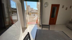 A room with a large window, a door, and a view of buildings outside. - Sea and sun appartment whole accommodation (napoli)
