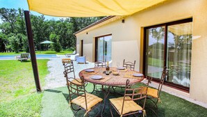 An outdoor dining area with a round table, chairs, and a yellow canopy. - Cozy home in Grignan with private swimming pool, can be inside or outside (Grignan)