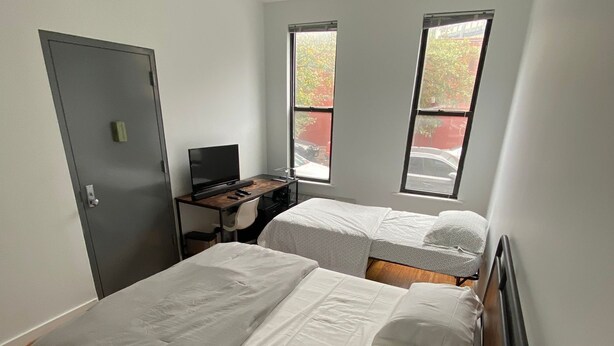 A room with two beds, a desk, and a computer. - room in brooklyn (Brooklyn)