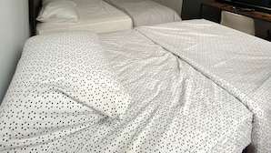A room with two beds, a door, a television, and a window. - room in brooklyn (Brooklyn)