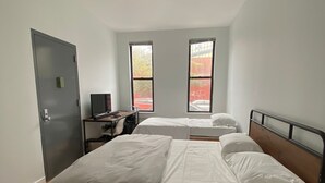 A bedroom with two beds, a desk, and a door. - room in brooklyn (Brooklyn)