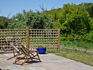 A wooden deck with a colorful striped chair and a blue planter. - 2 bedroom accommodation in Umberleigh (Umberleigh)