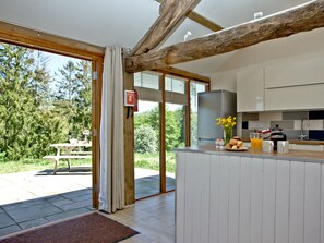 A modern kitchen with a large island, a fire extinguisher, and a view of the outdoors. - 2 bedroom accommodation in Umberleigh (Umberleigh)