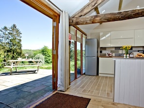 A kitchen with a refrigerator, a dining table, and a view of the outdoors. - 2 bedroom accommodation in Umberleigh (Umberleigh)