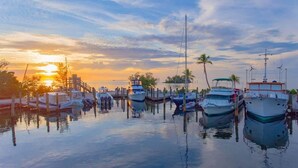 A marina with boats docked, a dock, and a sunset in the background. - 2BR Condo with Pool & Marina in Marathon (Marathon)