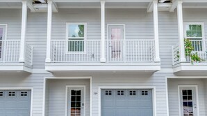 A two-story residential building with a paved driveway, a garage, and a balcony with a railing. - Looking for privacy minutes from 30A? Look no further! Come stay with us! (Santa Rosa Beach)
