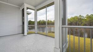 A covered porch with large windows overlooking a lake and forest. - Looking for privacy minutes from 30A? Look no further! Come stay with us! (Santa Rosa Beach)