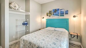 Un dormitorio con cama, armario con estantes y decoración en la pared.