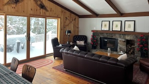 A cozy living room with a fireplace, leather sofa, and a ceiling fan. - Mount Snow Vermont - Ski - Snowboard - 6 miles (Wilmington)