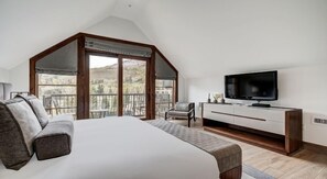 A bedroom with a large bed, a TV, a balcony with a view, and a chair. - Valley View Residence with Access to Pool (Vail)