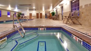 An indoor swimming pool with a 3ft depth marker, lounge chairs, and a tiled floor.