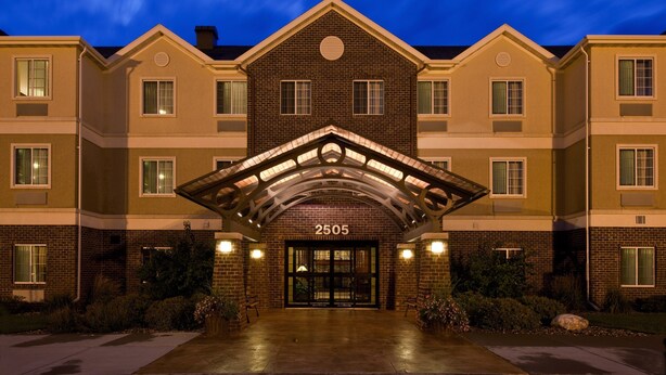 A multi-story hotel with a brick facade, a central entrance with a canopy, and the number 2505 displayed above the doors.